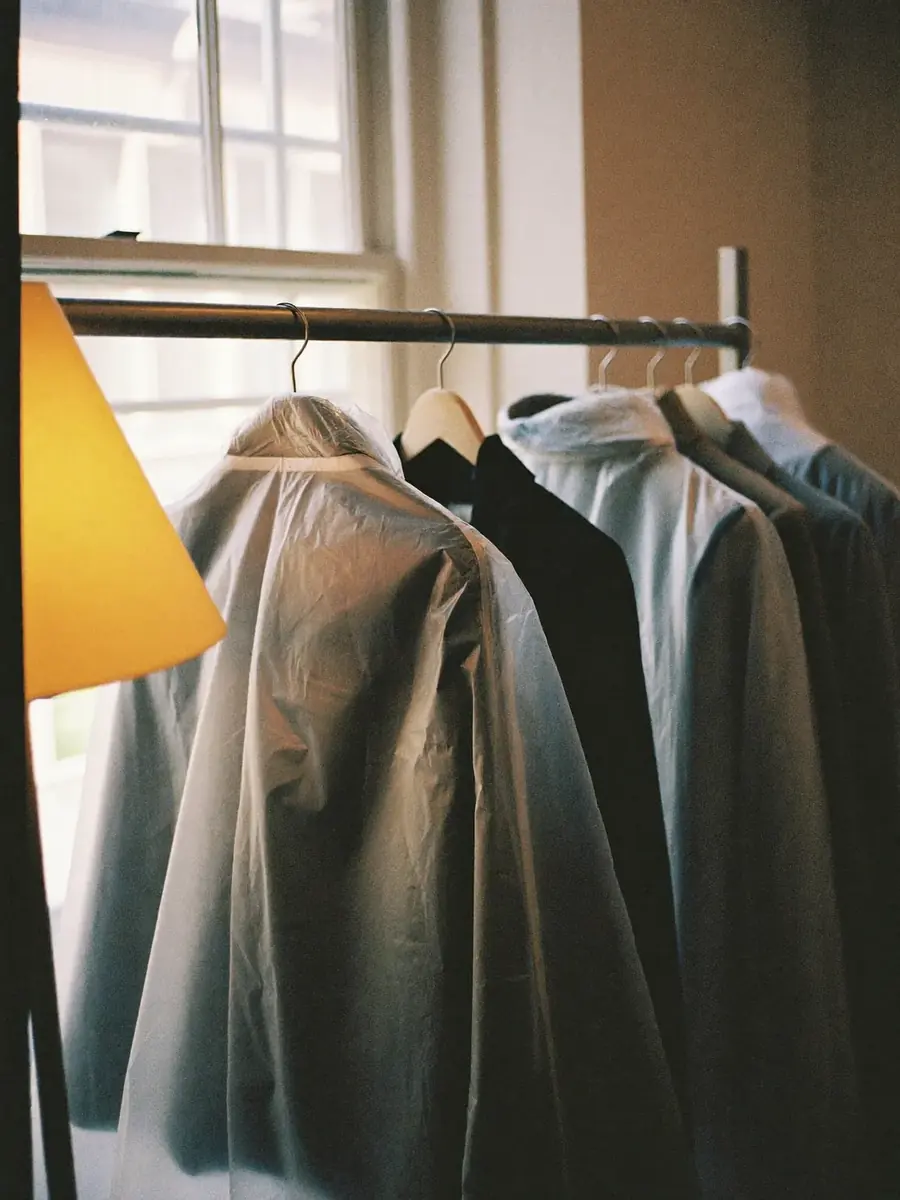 A rail of finished garments in covers waiting for collection